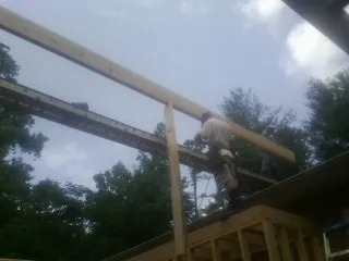 Carpenter setting a ridge beam over a new addition frame — Ice Dam Removal by Roofing Brothers in Merrittstown