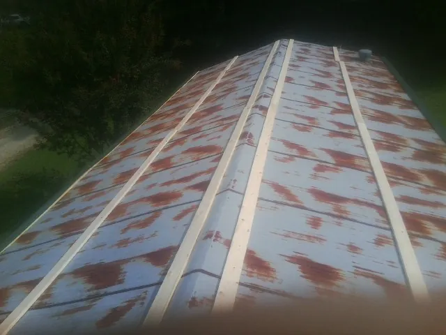 Rusted metal roof panels with new wood purlins before replacement — Storm Damage Roof Repair in Merrittstown by Roofing Brothers