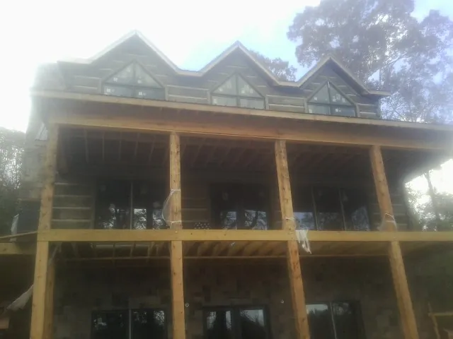 Dormers and porch framing on a large log home under construction — Roof Coating work by our crew in Merrittstown
