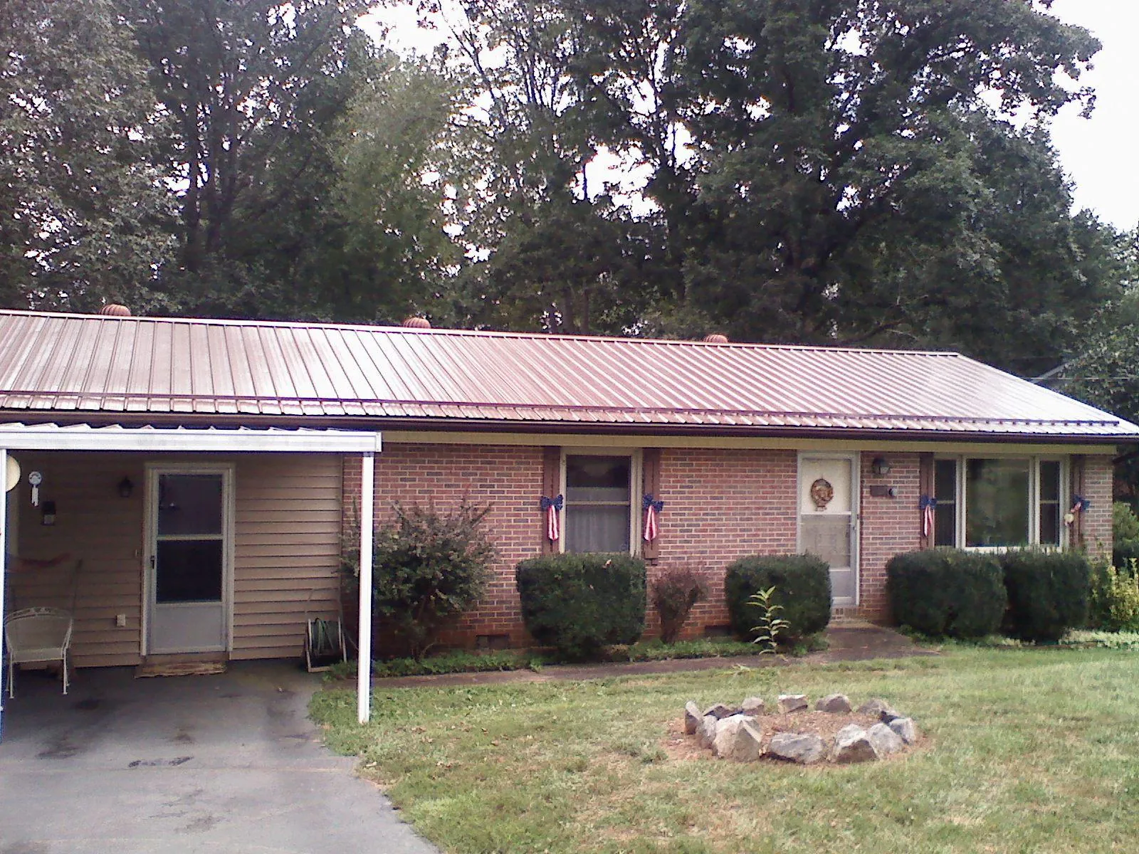 Bronze metal roof and carport on a brick ranch home — Roof Repair work by our crew in Merrittstown