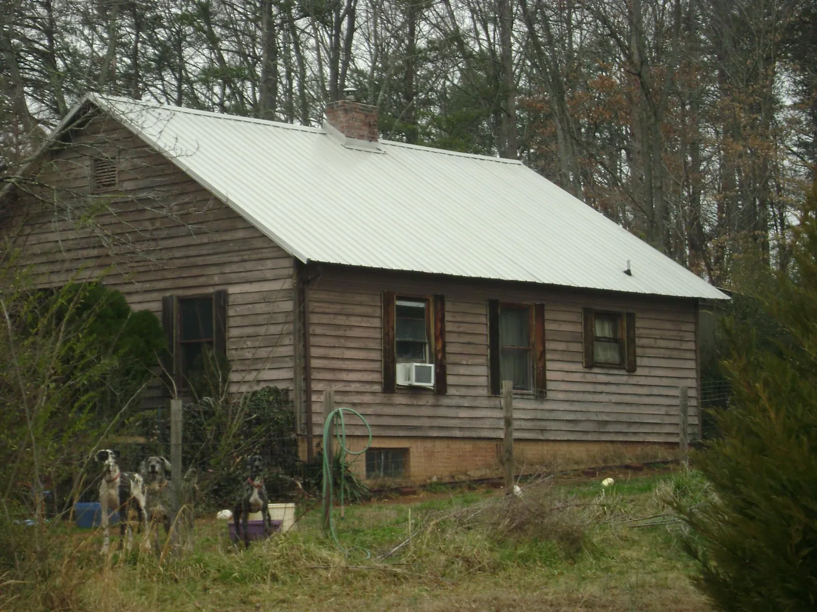 White metal roof on an old wood sided farmhouse, from a Metal Roof Installation job in Merrittstown